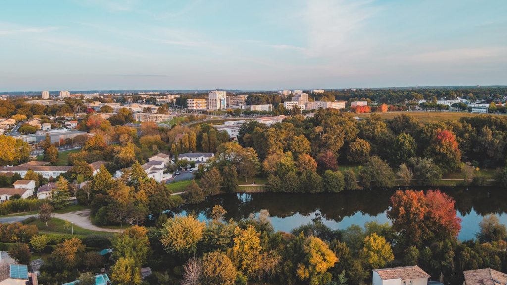 A beautiful aerial view of Bordeaux showcasing vibrant autumn colors and a serene lake.